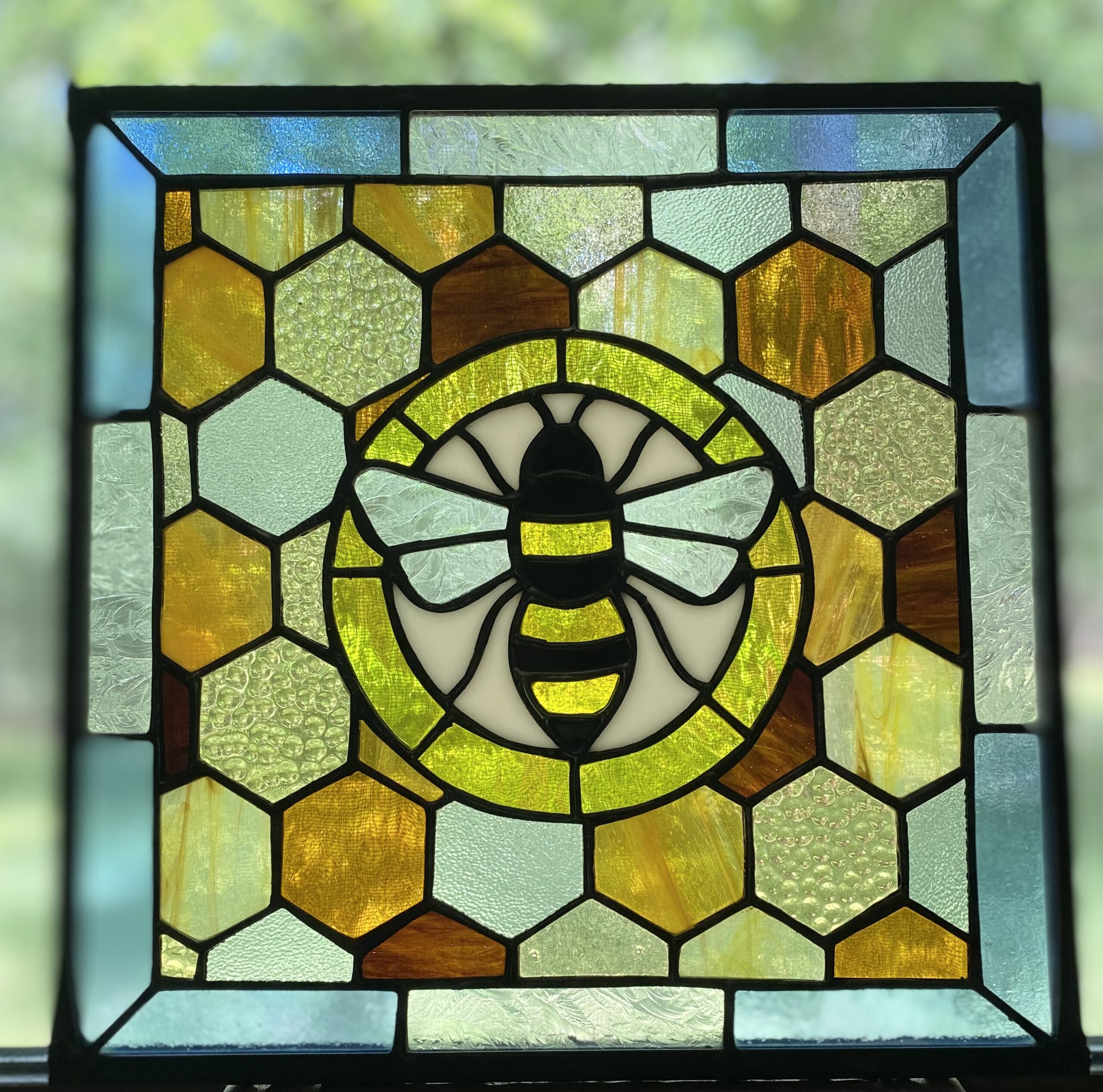 stained glass window of a bee surrounded by honeycomb